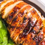 Baked Balsamic Chicken Breast 3 Baked Balsamic Chicken Breast garnished with herbs on a plate.