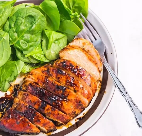Baked balsamic chicken breast with herbs and spices on a plate