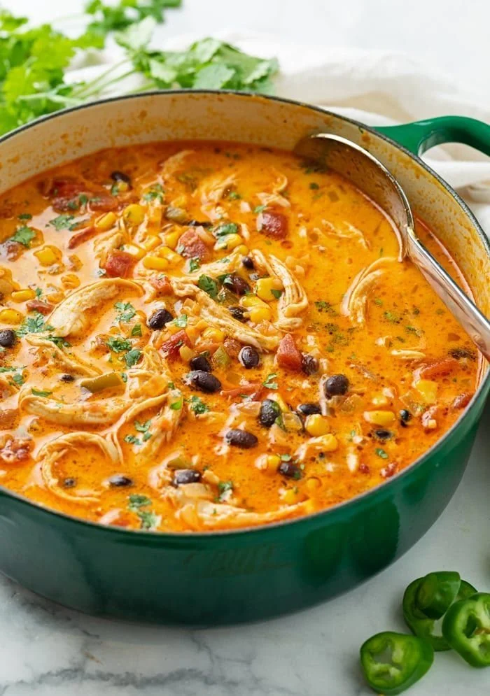 Bowl of cheesy chicken enchilada soup garnished with cilantro and tortilla strips