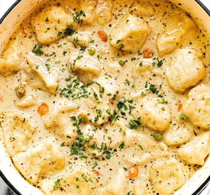 Bowl of Chicken Dumpling Soup with fresh herbs and dumplings