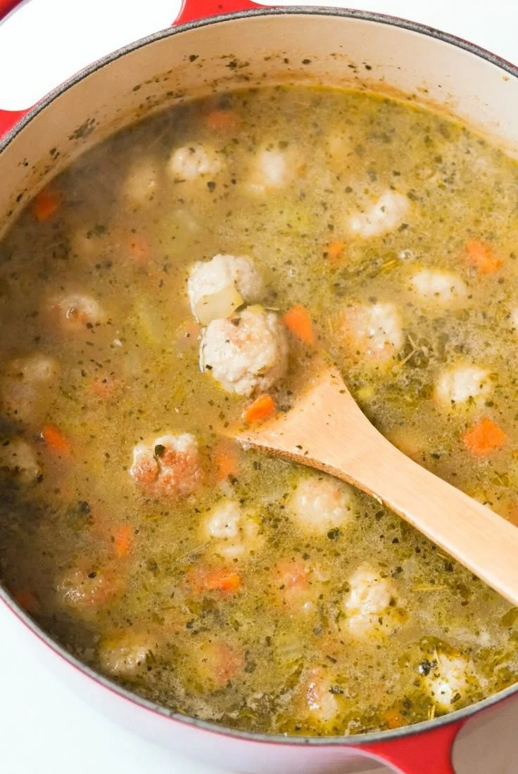 Bowl of Chicken Meatball Soup garnished with herbs