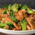 Chinese Chicken and Broccoli served on a plate with rice and vegetables