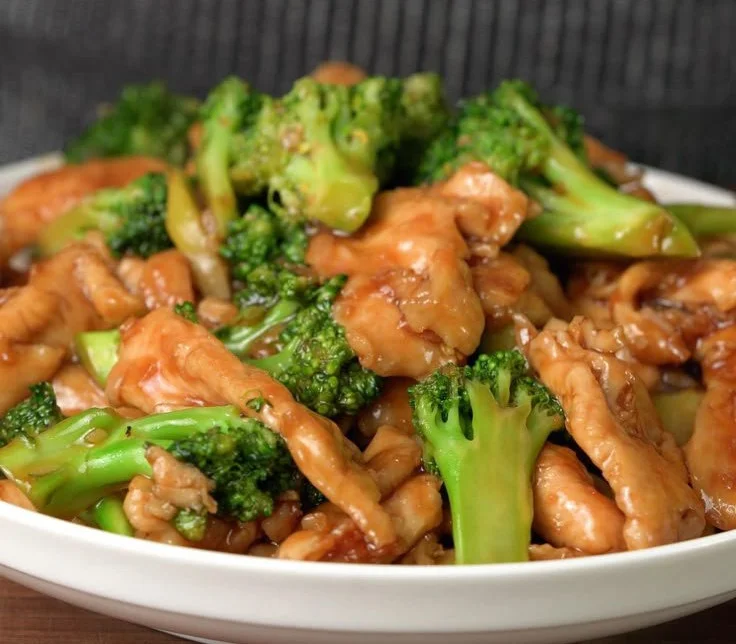Chinese Chicken and Broccoli served on a plate with rice and vegetables