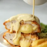Classic Chicken Cordon Bleu 3 Delicious Classic Chicken Cordon Bleu served on a plate with herbs and side dishes.