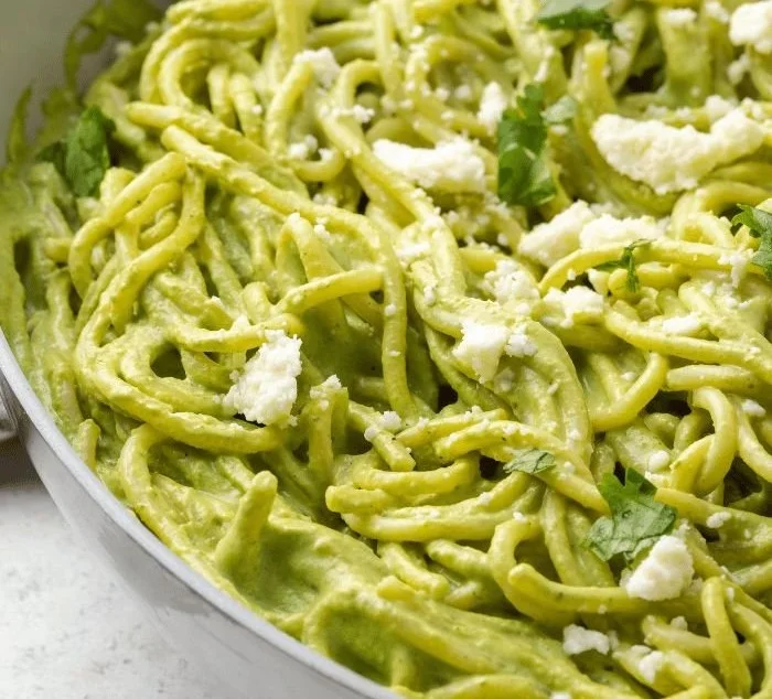 Creamy Mexican green spaghetti served with vibrant sauce and fresh toppings