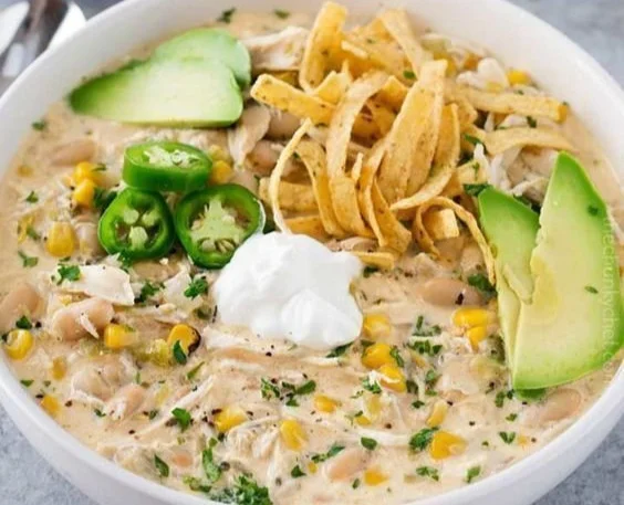 Bowl of creamy white chicken chili topped with cilantro and cheese