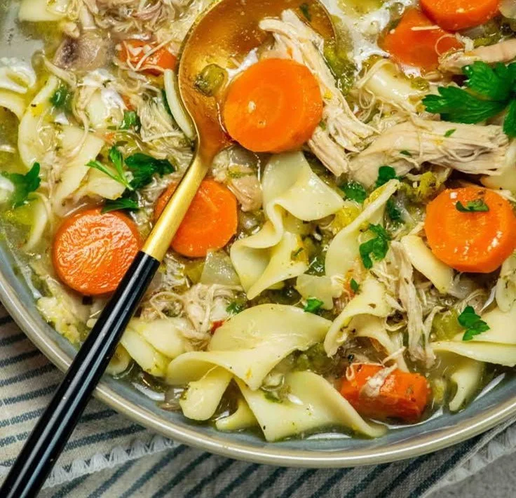 Bowl of comforting rotisserie chicken noodle soup with herbs and vegetables