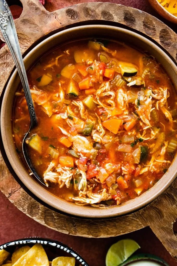 Bowl of easy Mexican chicken soup garnished with fresh herbs and avocado.