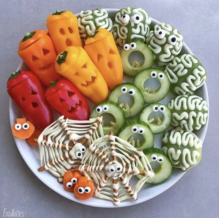 Variety of Halloween edibles including strawberry ghosts and pretzel vampires.