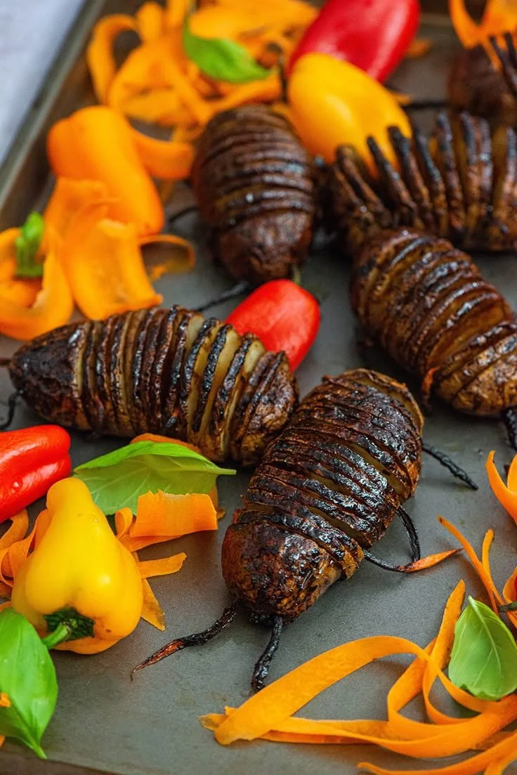 Deliciously prepared Hasselback potato served on a plate at Nibbles and Feasts.