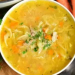 Bowl of homemade chicken noodle soup with fresh ingredients.