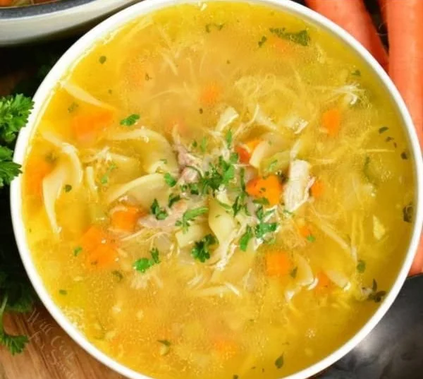 Bowl of homemade chicken noodle soup with fresh ingredients.