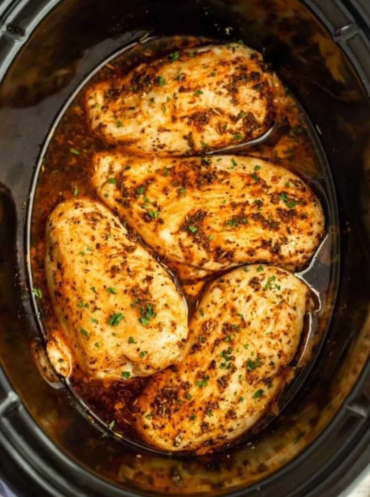 Slow cooker chicken breasts cooked to perfection in a flavorful sauce.