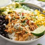 Slow Cooker Chicken Burrito Bowl 3 Slow cooker chicken burrito bowl topped with fresh ingredients and toppings.