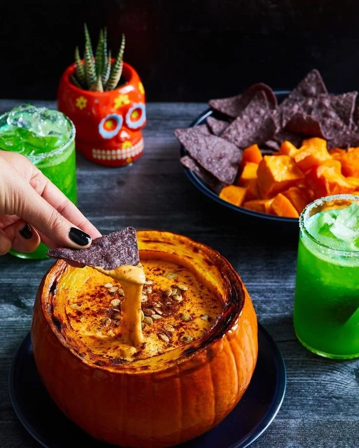 Spicy pumpkin queso served in a bowl with chips on the side