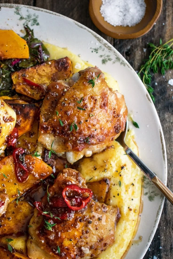 Spicy maple mustard chicken served with creamy polenta in a bright dish