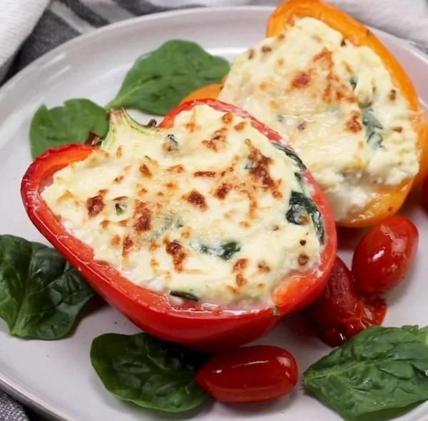 Plate of spinach and ricotta stuffed shells topped with marinara sauce and cheese.
