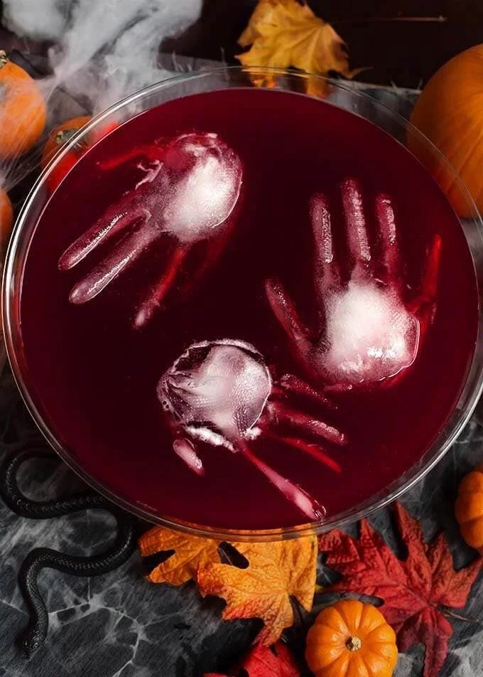 Spooky Halloween party punch in a cauldron with creepy garnishes.