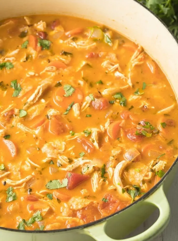 A bowl of the best chicken tortilla soup garnished with tortilla strips and cilantro.