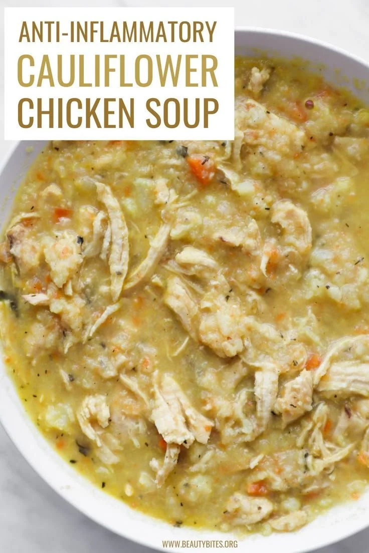 Bowl of creamy cauliflower chicken soup topped with herbs and spices.