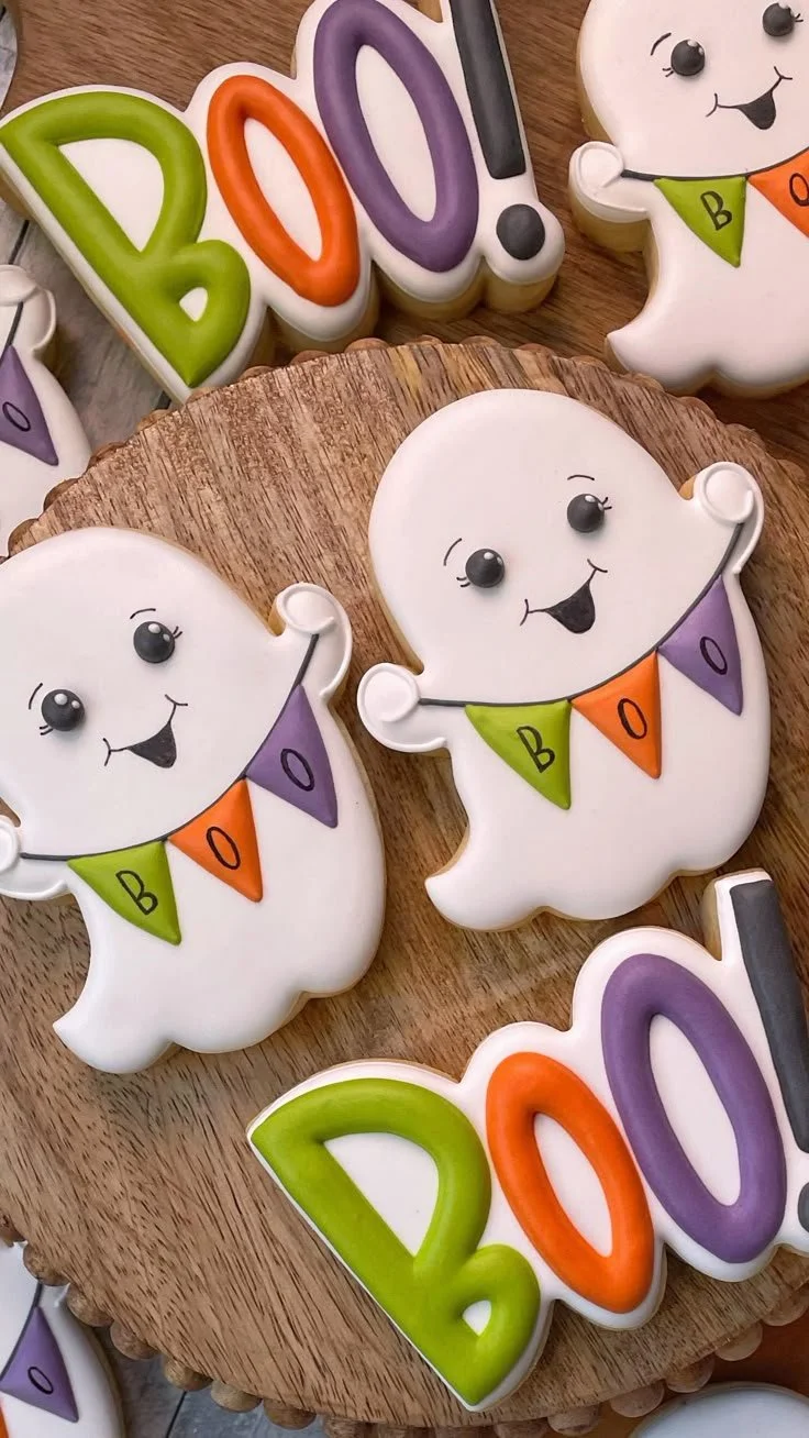 Colorful Halloween cookies displayed with ghost-themed designs and decorations.