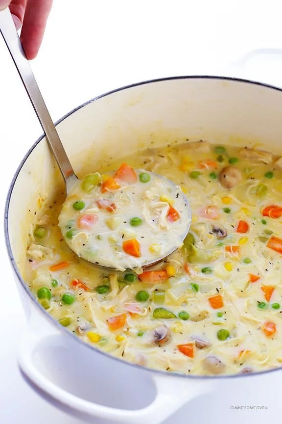 Bowl of cozy chicken pot pie soup with vegetables and herbs