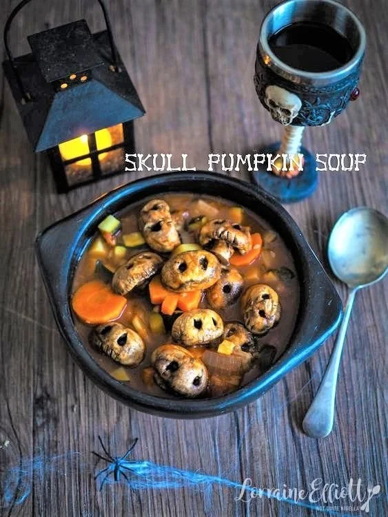 Ghoulish skull and pumpkin soup in a spooky serving bowl for Halloween