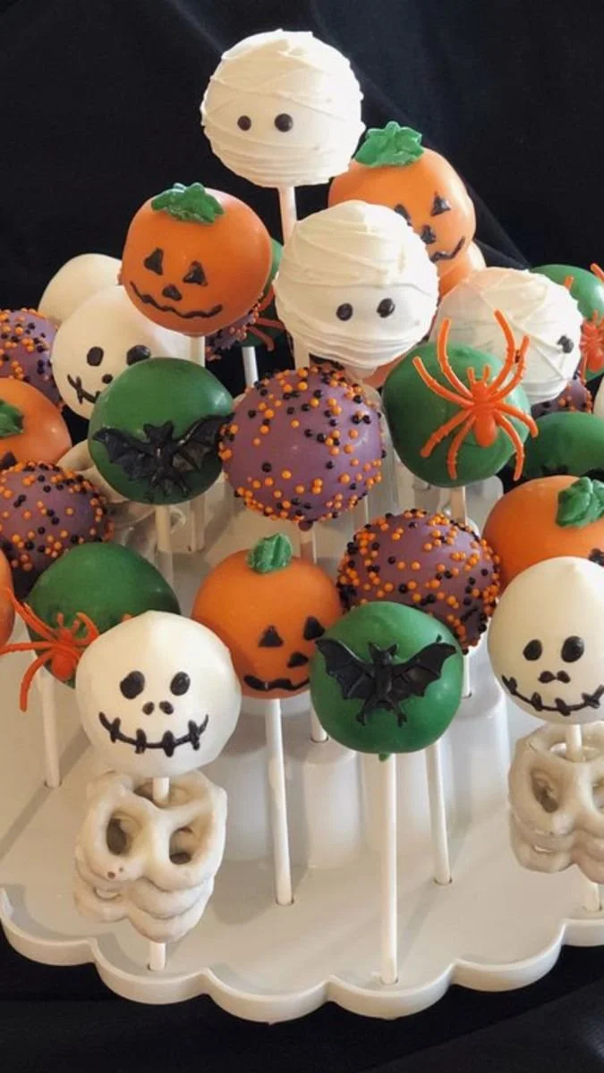 Halloween cake pops decorated as pumpkins and jack-o'-lanterns for festive treats