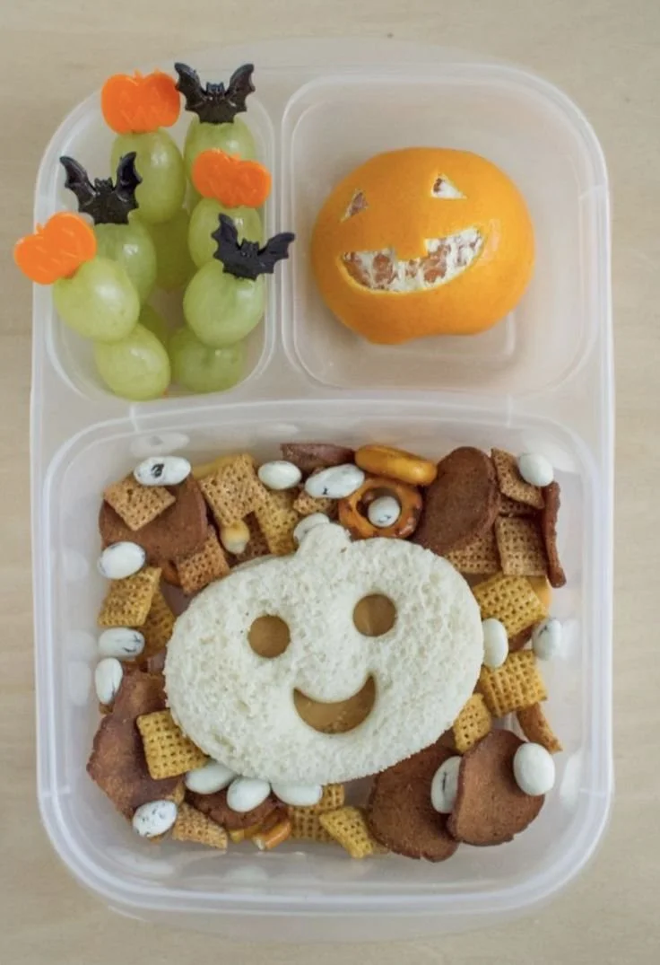 Halloween pumpkin bento lunch box with themed snacks and treats