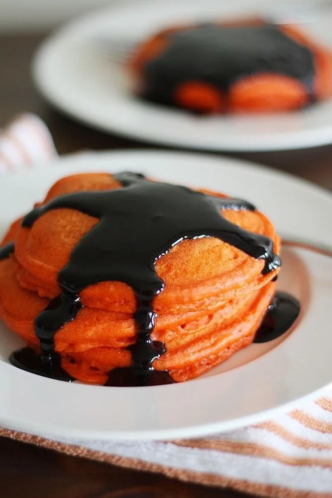 Delicious pumpkin pancakes drizzled with cinnamon syrup on a plate