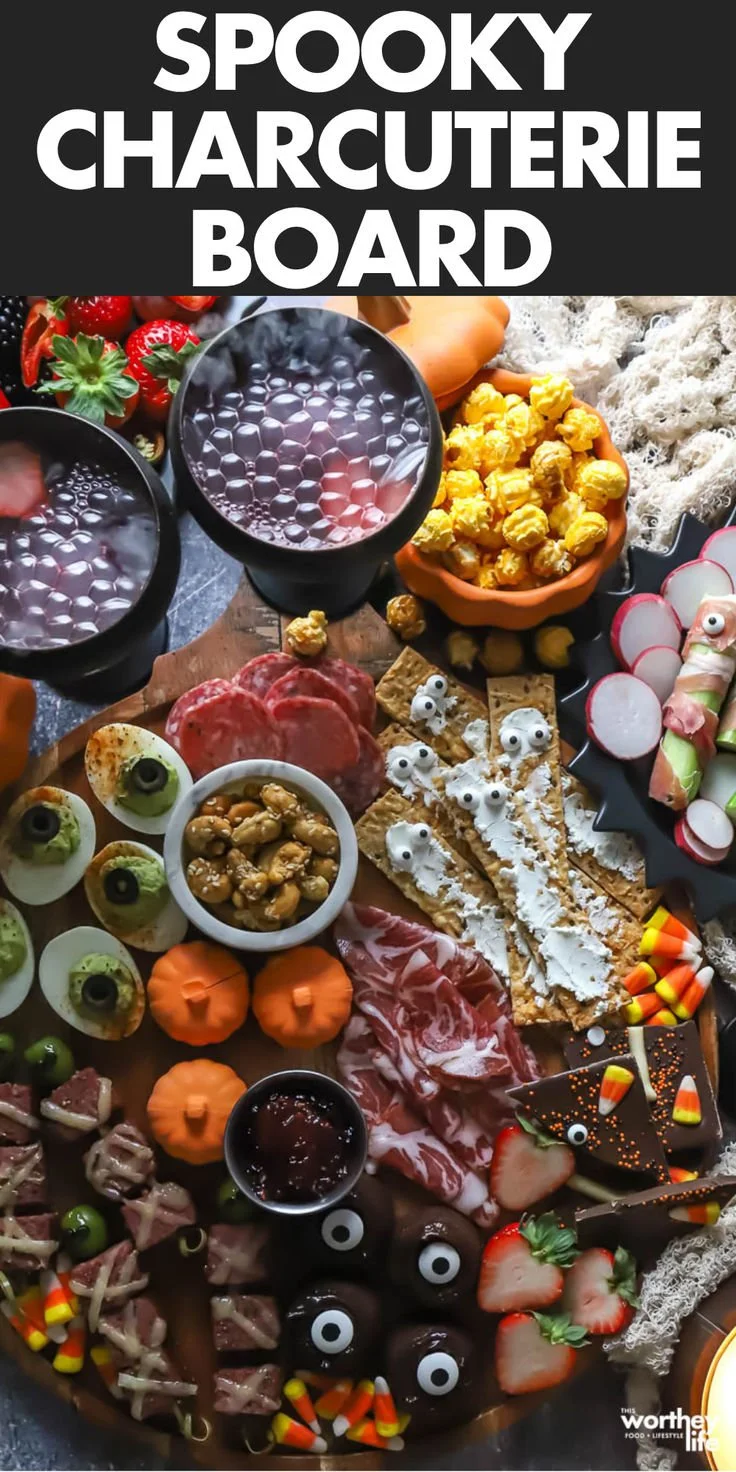Spooky charcuterie board with Halloween-themed treats and decorations