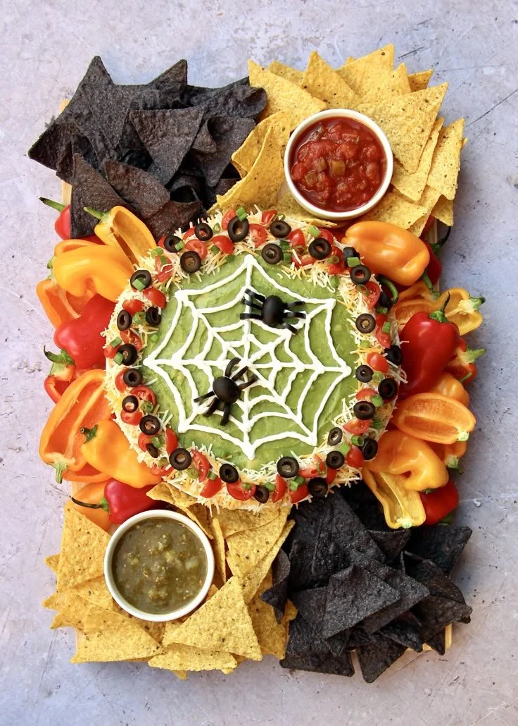 Spooky Halloween food boards featuring spider web taco dip for parties.