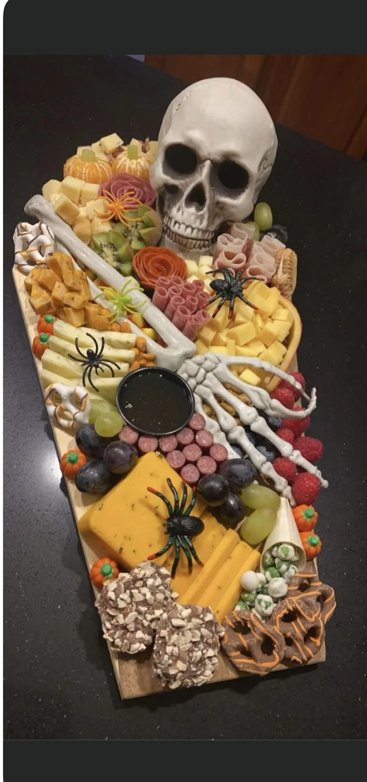 Spooky Halloween buffet with skeleton charcuterie board and festive snacks.